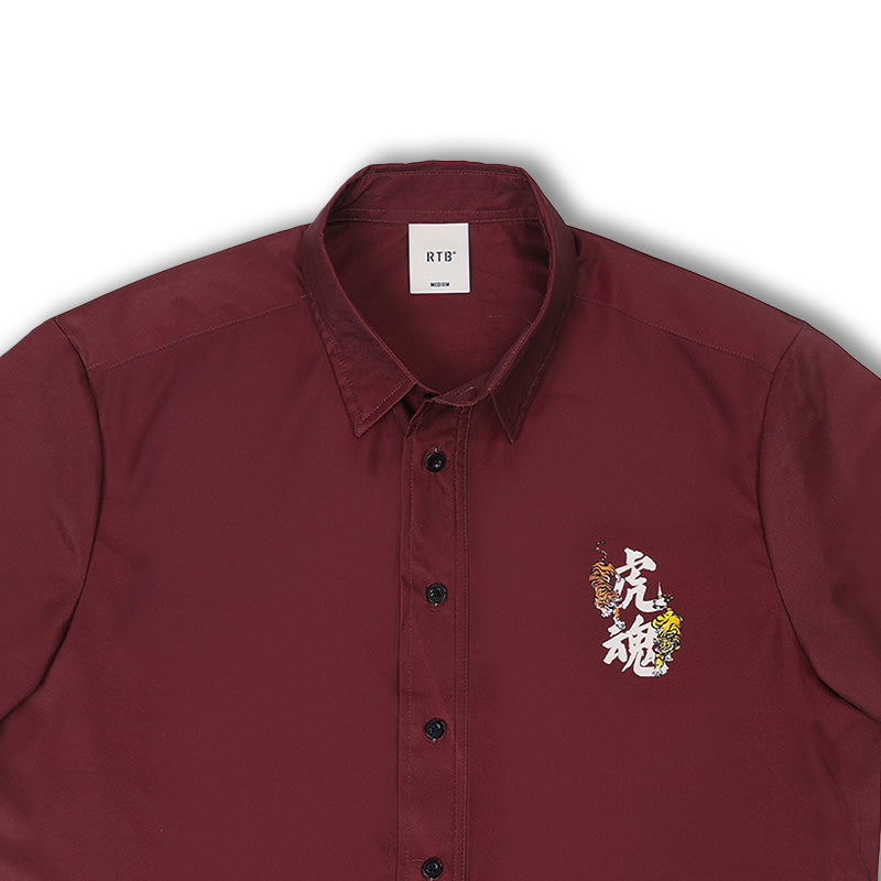 Burgundy resort shirt close-up, button-up front with tiger emblem on left chest
