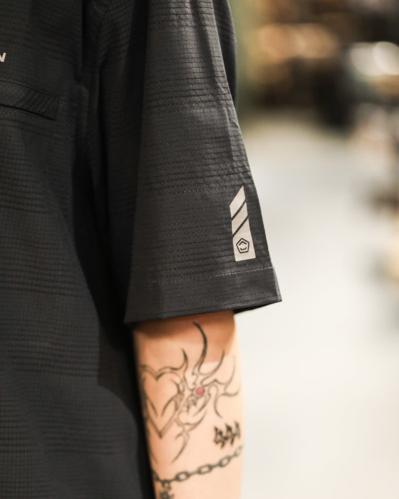 Men's black short-sleeve shirt sleeve with small logo patch near hem