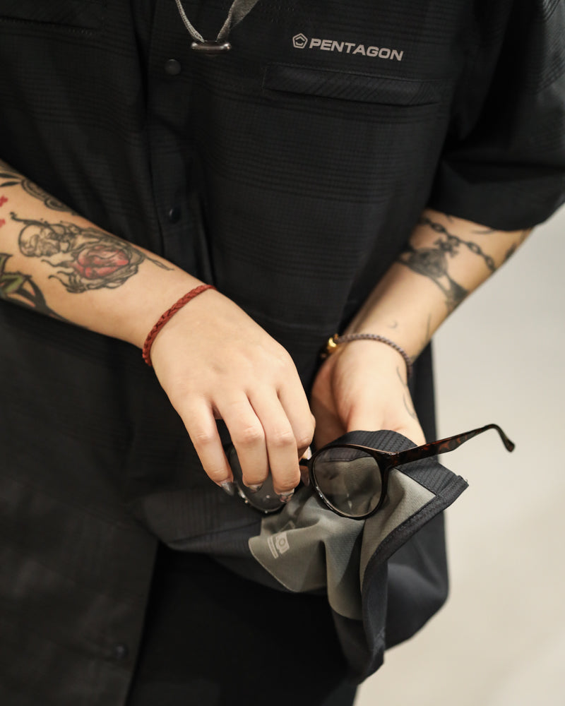 Men's black short-sleeve button-up shirt close-up with chest logo