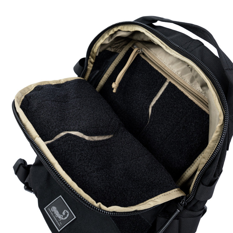 Black assault backpack with open main compartment and padded interior divider