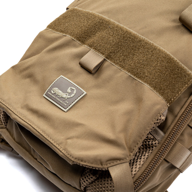 Coyote brown assault pack flap with hook-and-loop label and zipper pocket