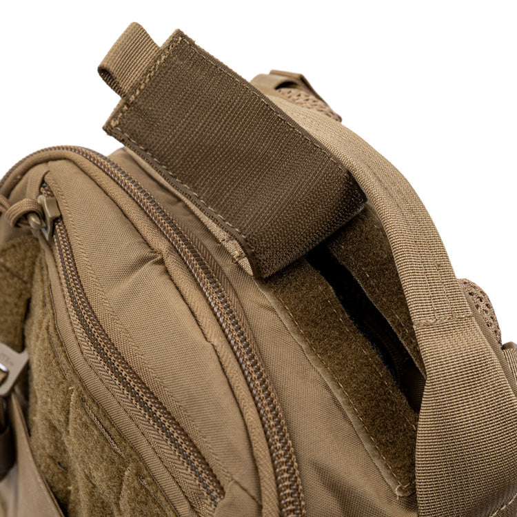 Tan assault pack close-up of webbing strap and padded fabric panel