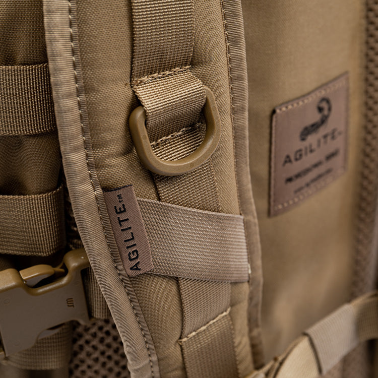 Tan assault pack back panel with AGILITE label and looped webbing attachment